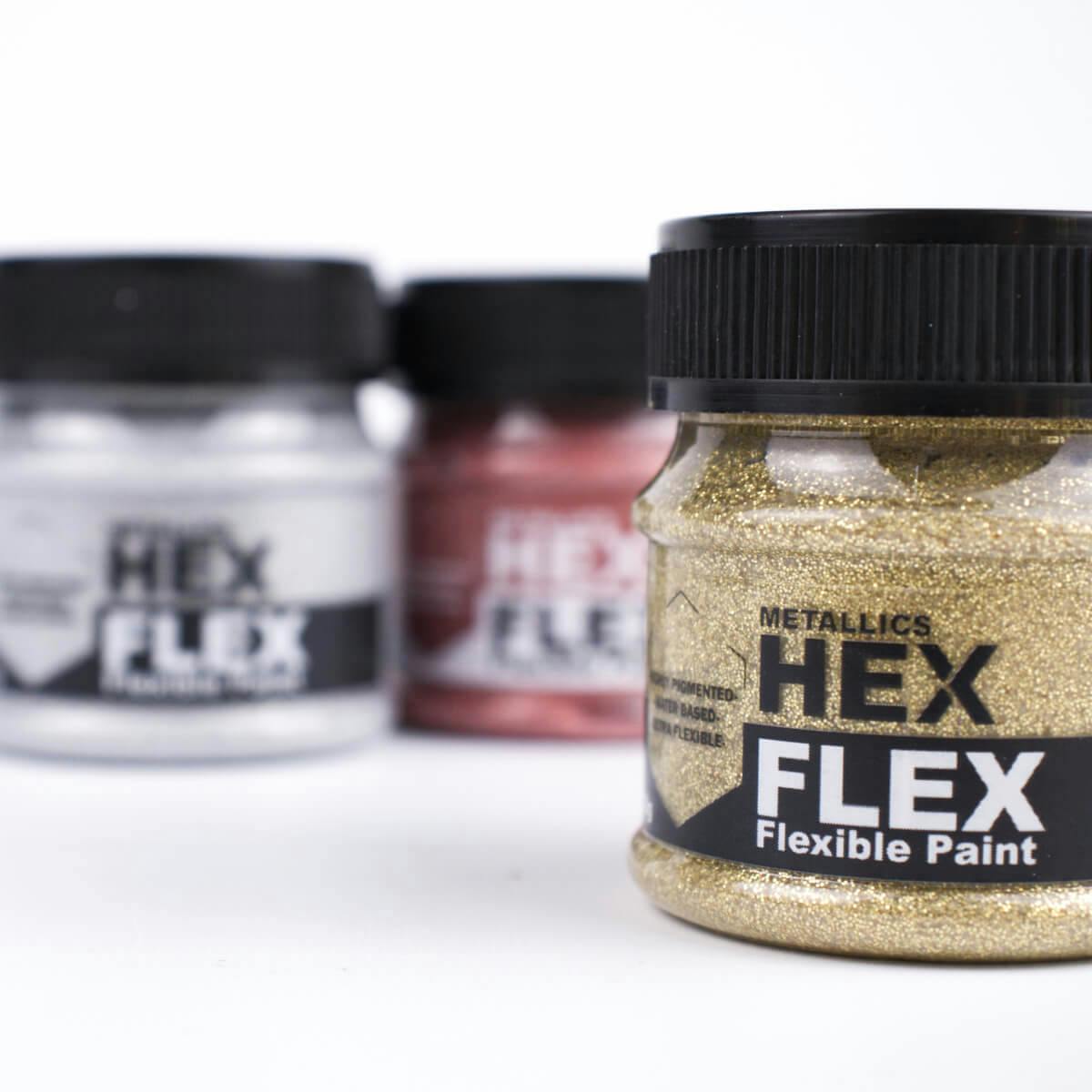 Detailní záběr na zlatou třpytivou HexFlex metalickou barvu s ostatními barvami v pozadí