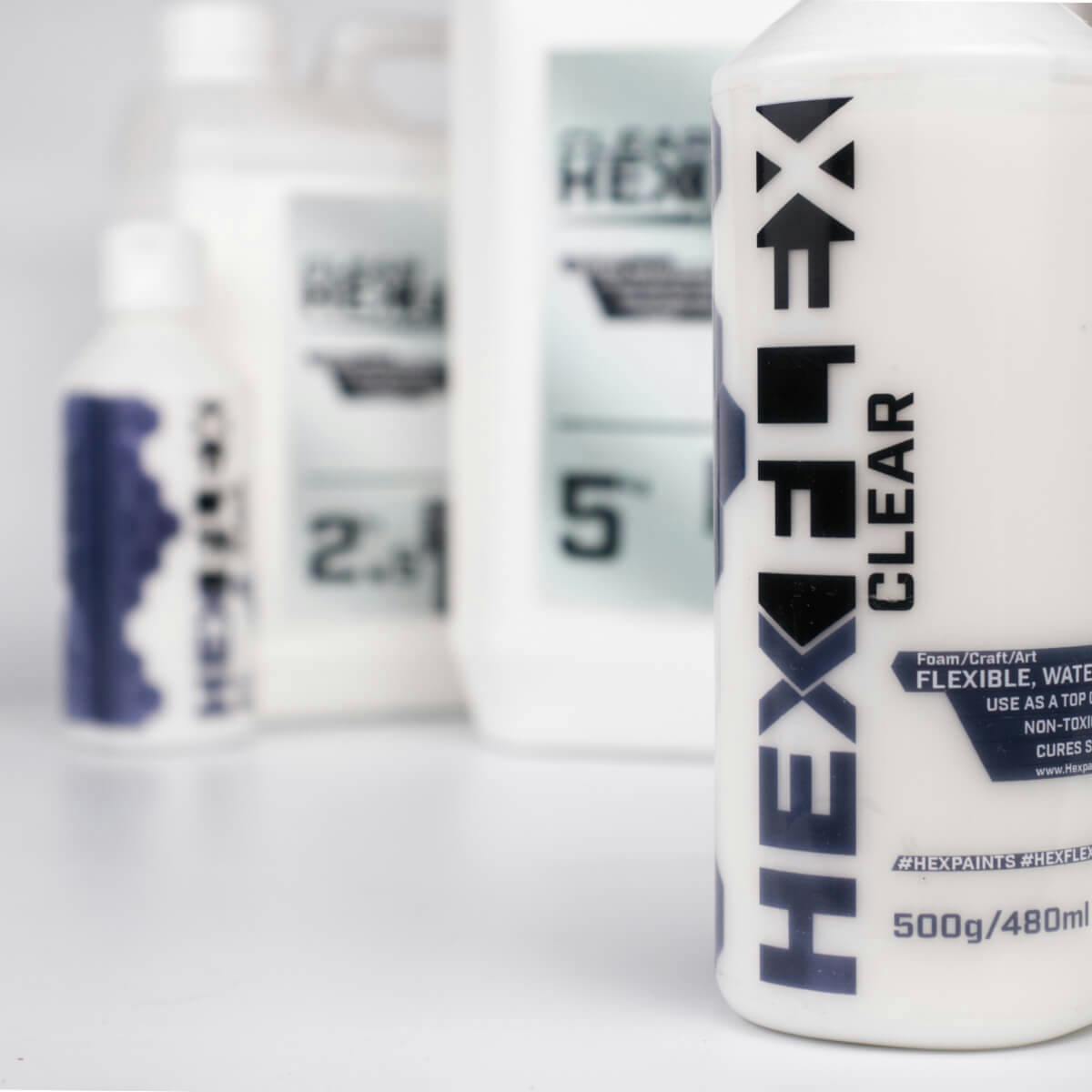 Detailní záběr na HexFlex Primer v průhledné variantě s menší lahví v pozadí